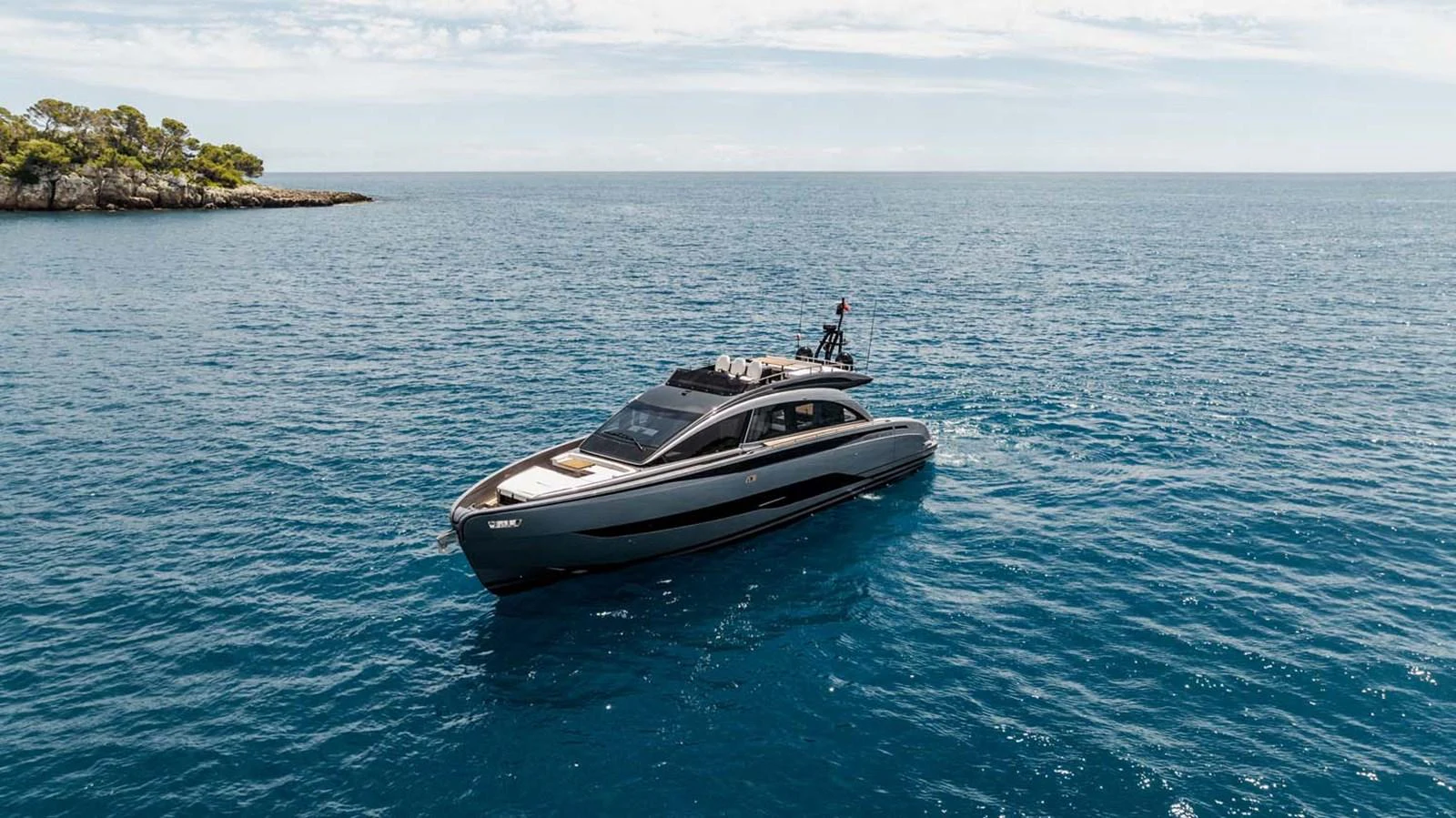 A sleek, modern yacht cruises gracefully on calm blue waters under a clear sky. aboard REEMA Yacht for Sale