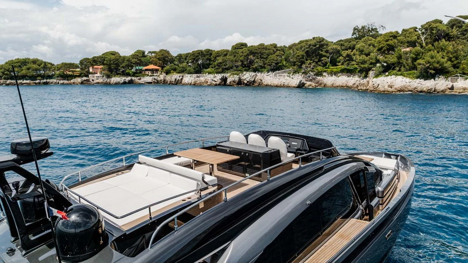 The yacht's aft deck offers a luxurious lounging area with scenic views of the coastline. aboard REEMA Yacht for Sale