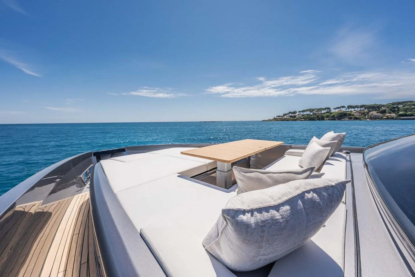 The foredeck of the yacht features a comfortable lounging area with plush cushions and a table, perfect for enjoying the scenic ocean views. aboard REEMA Yacht for Sale