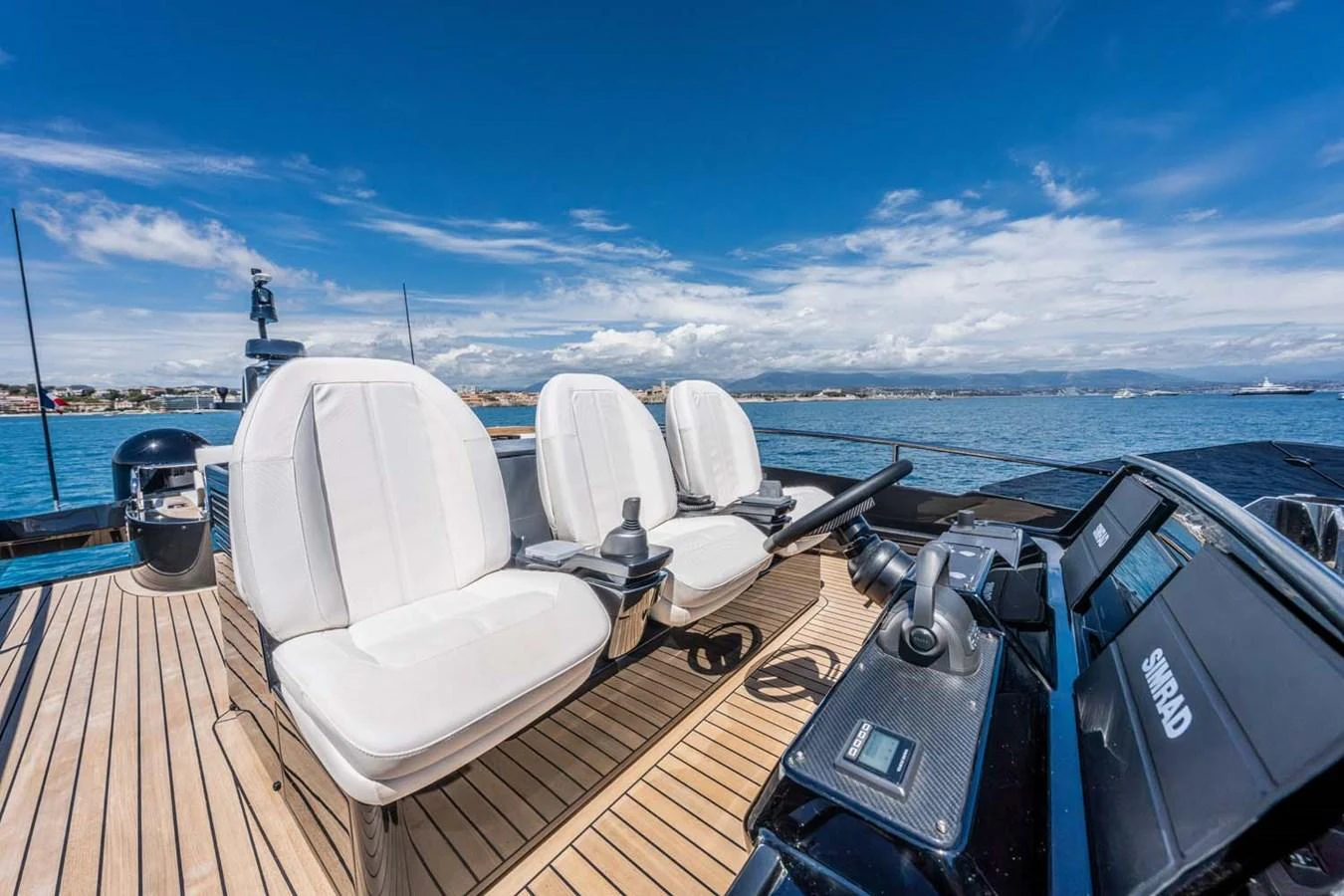 The yacht's helm features sleek controls and comfortable seating with a stunning ocean backdrop. aboard REEMA Yacht for Sale