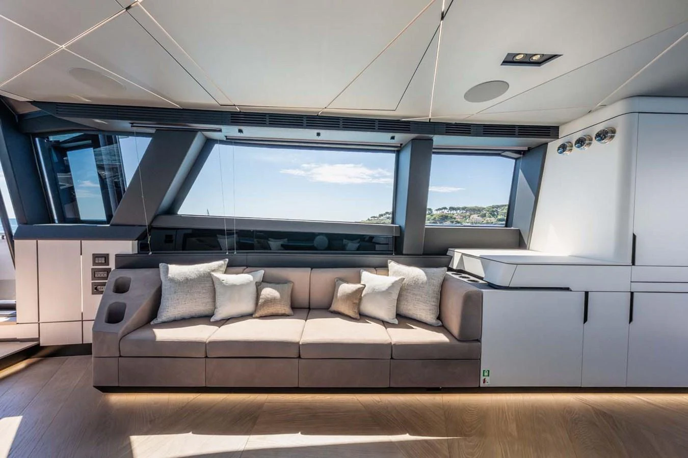 The salon features a modern design with a large, comfortable sofa and ample natural light. aboard REEMA Yacht for Sale
