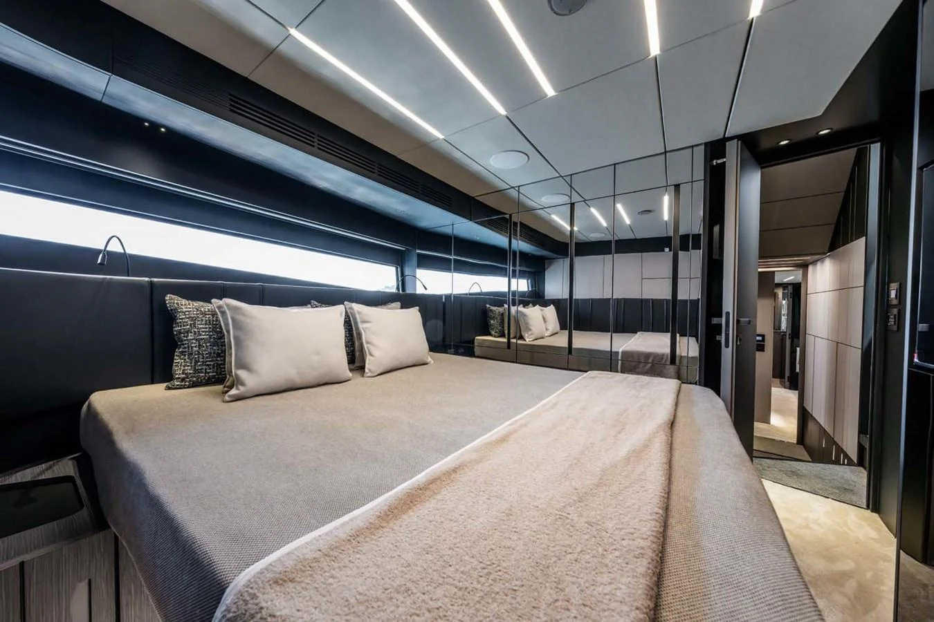 The stateroom features a luxurious bed with modern lighting and sleek design elements. aboard REEMA Yacht for Sale