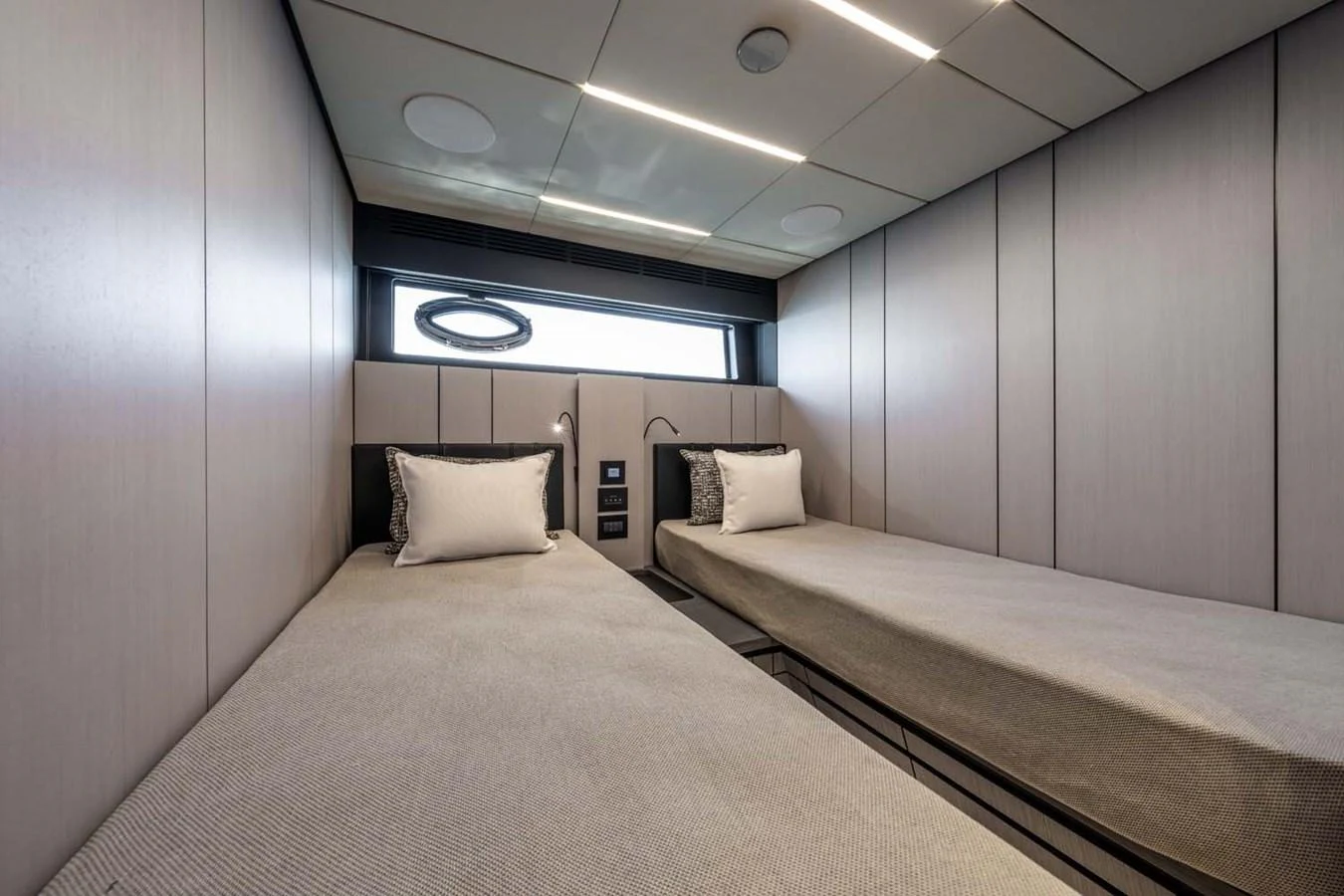 The twin stateroom features sleek, modern design with two single beds and ample storage. aboard REEMA Yacht for Sale