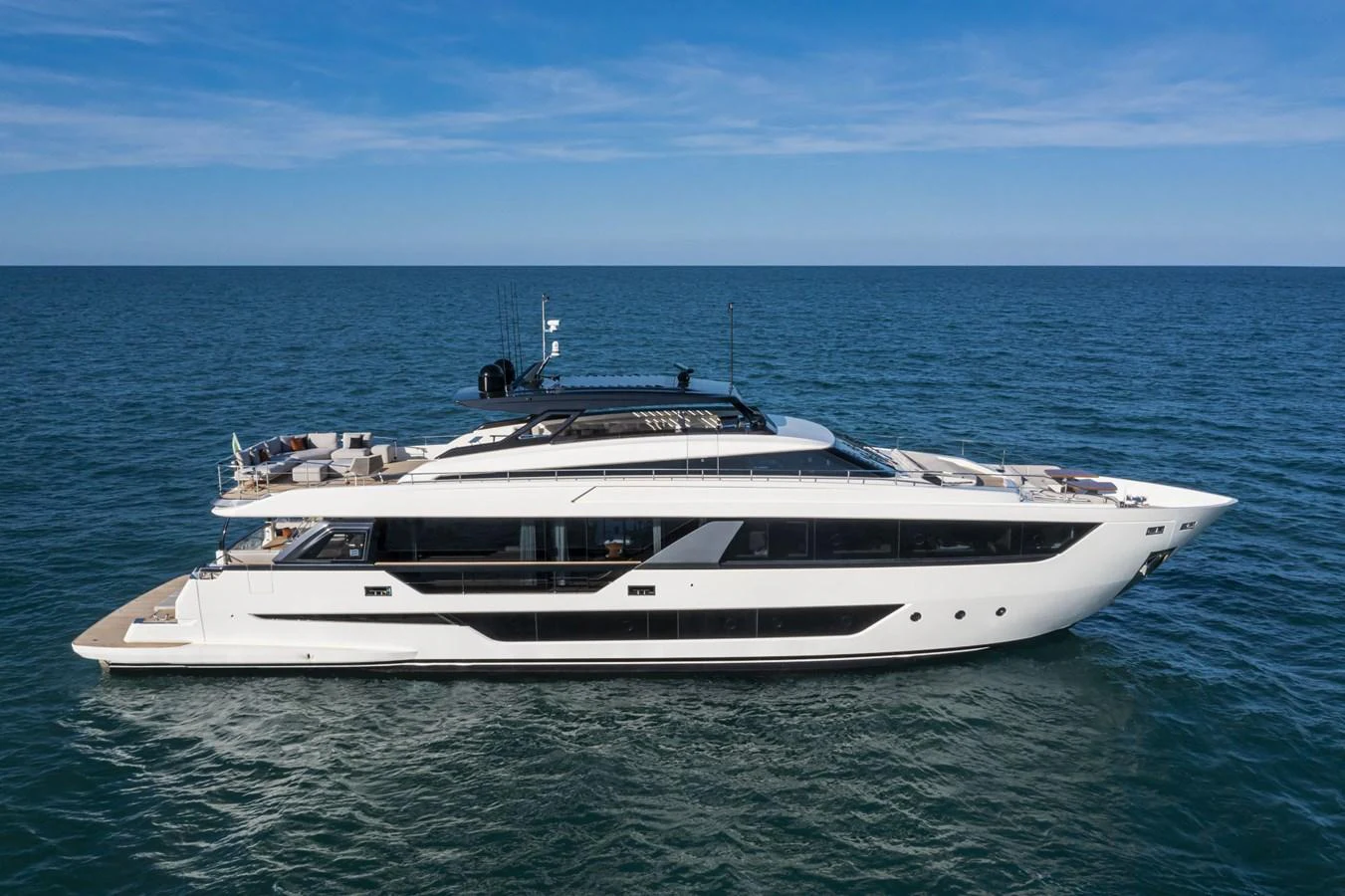 A sleek and modern yacht cruising on the open sea under a clear blue sky. aboard DANIMA Yacht for Sale