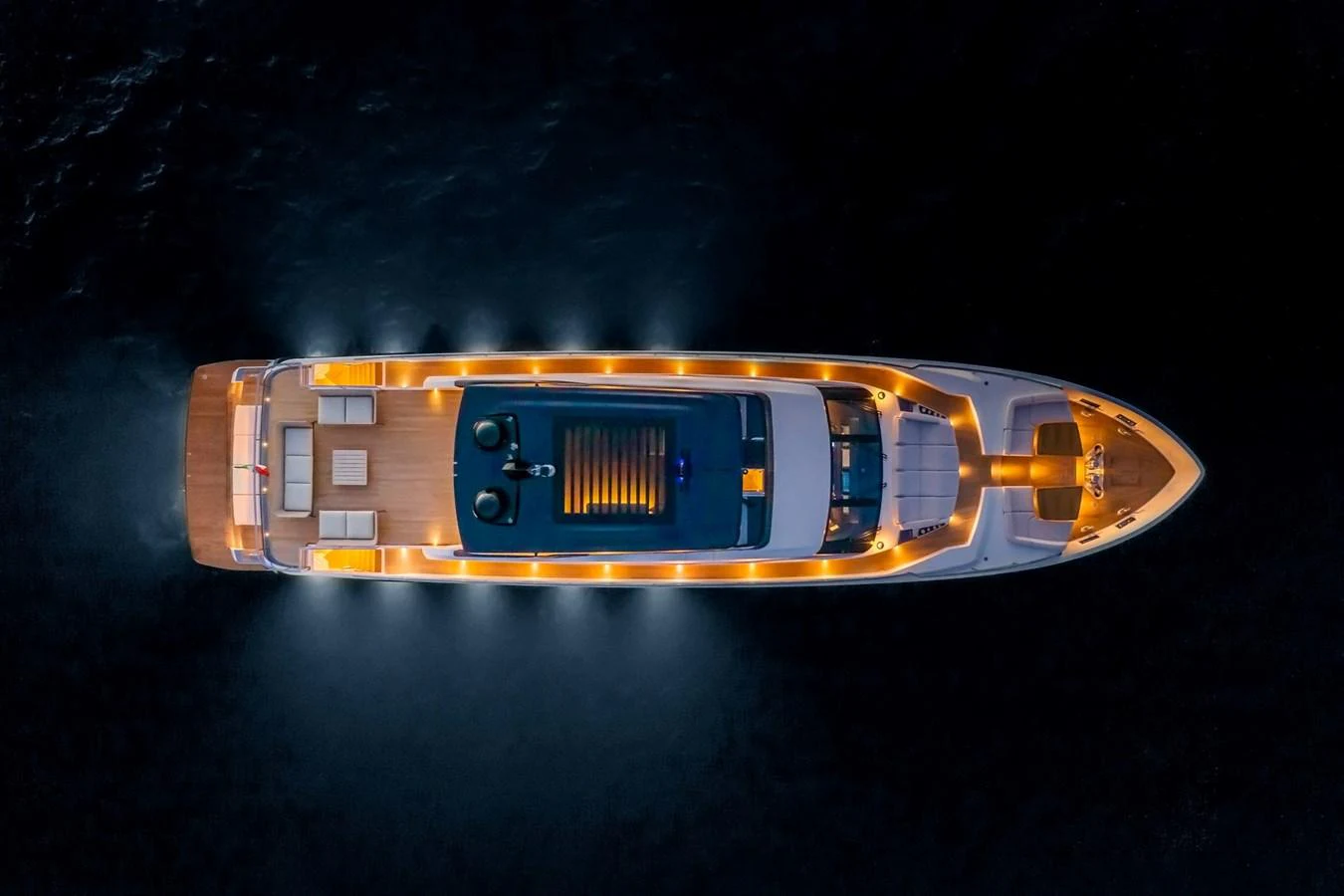 A stunning aerial view of a yacht illuminated against the night sea. aboard DANIMA Yacht for Sale