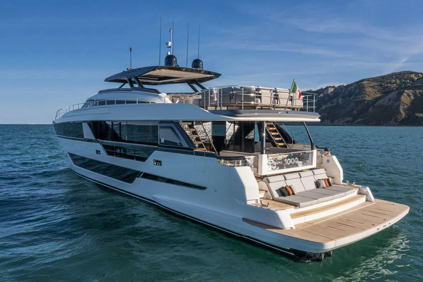 A sleek and modern yacht cruising on calm waters with a scenic backdrop. aboard DANIMA Yacht for Sale
