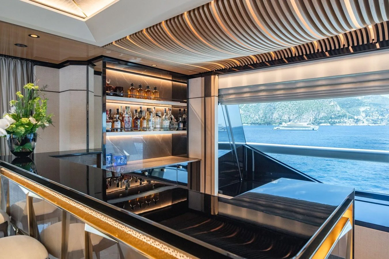 The yacht's interior bar area features a sleek design with a stunning view of the sea. aboard MALIA Yacht for Sale