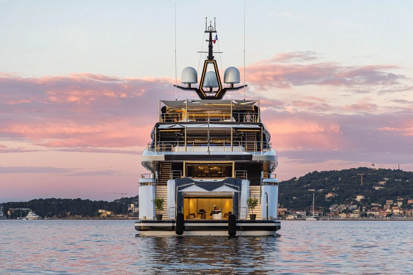 The yacht is anchored on calm waters with a picturesque sunset backdrop. aboard MALIA Yacht for Sale