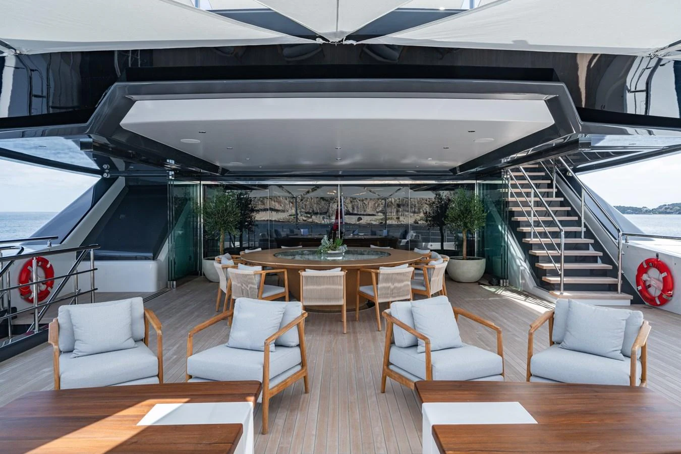 The aft deck offers a spacious and elegant outdoor seating area with comfortable chairs and a dining table, perfect for alfresco dining and relaxation. aboard MALIA Yacht for Sale