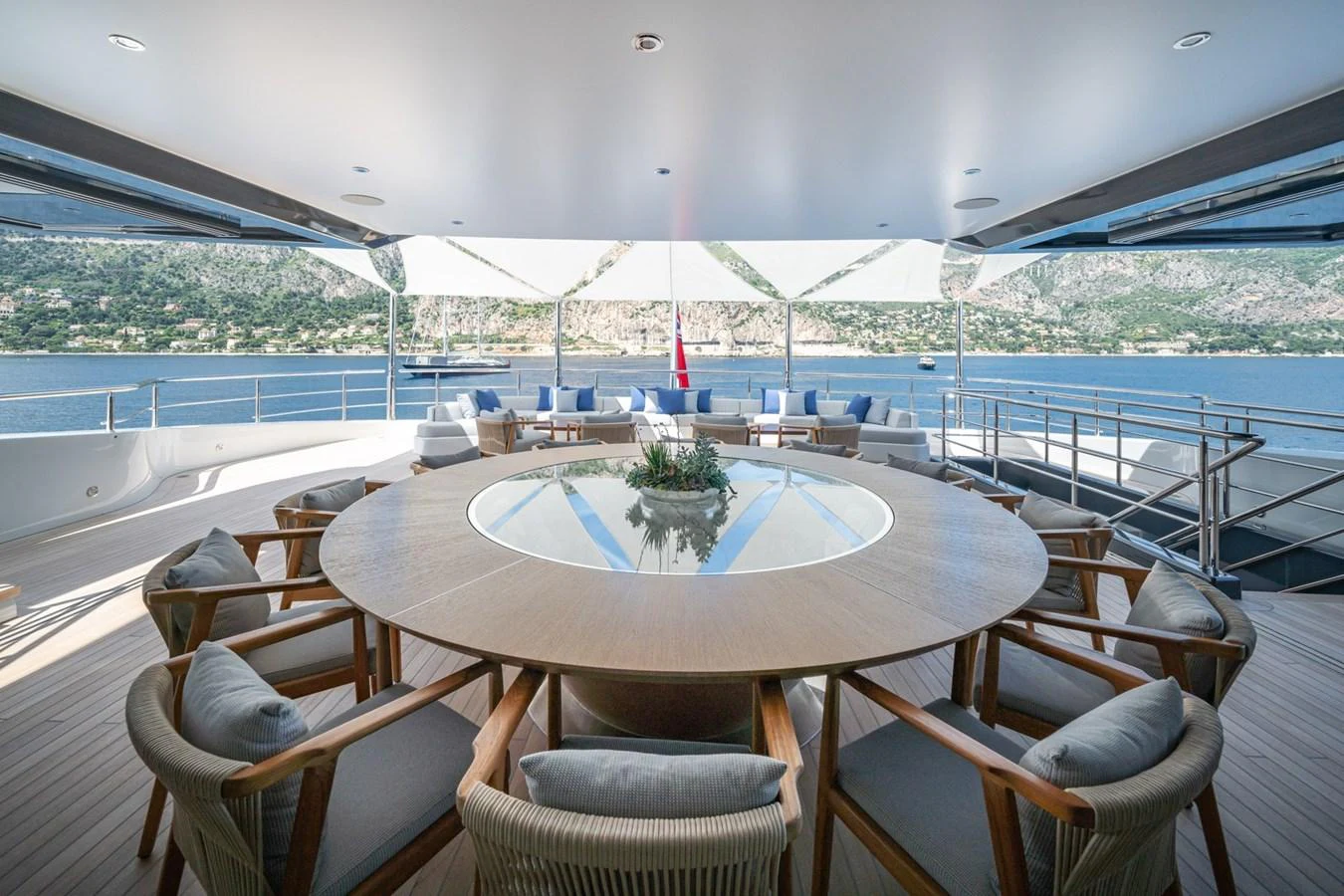The aft deck features a spacious circular dining area with panoramic views of the surrounding waters. aboard MALIA Yacht for Sale