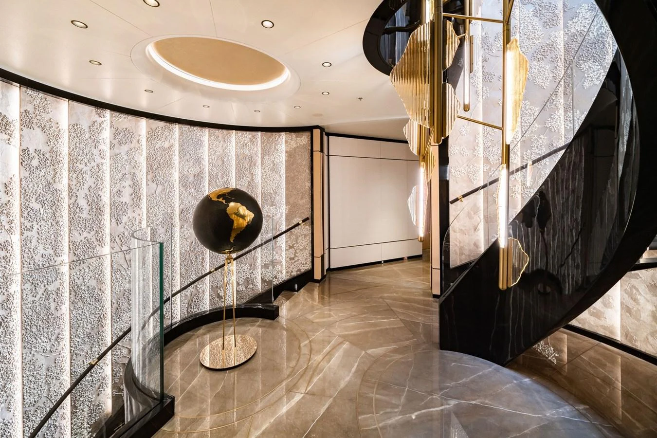 The yacht's foyer features a stunning spiral staircase and elegant decor. aboard MALIA Yacht for Sale