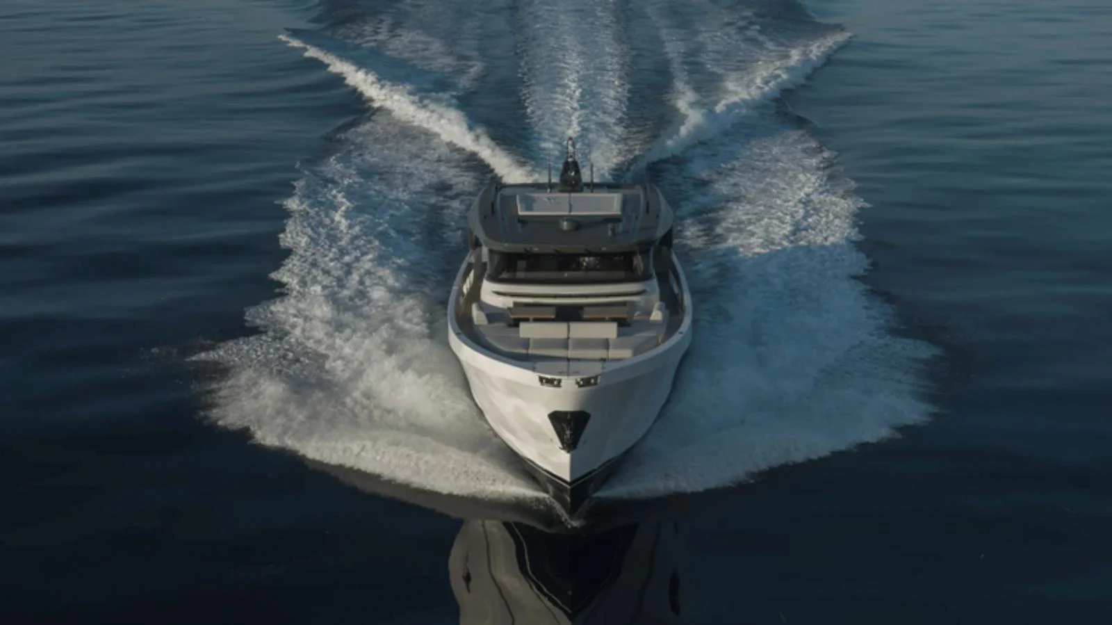 A sleek yacht cuts through calm waters, leaving a trail of gentle waves behind. aboard BARIC Yacht for Sale