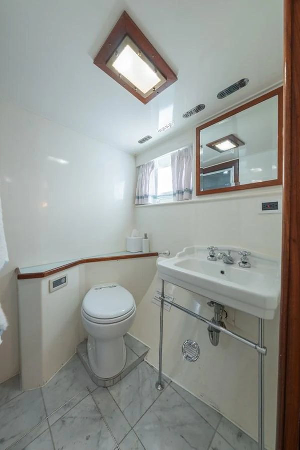 The yacht's bathroom features a compact and functional design with a modern sink and toilet. aboard INNISFAIL Yacht for Sale