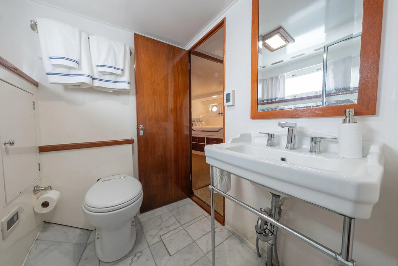 The yacht's bathroom features a clean and modern design with a large mirror and ample lighting. aboard INNISFAIL Yacht for Sale