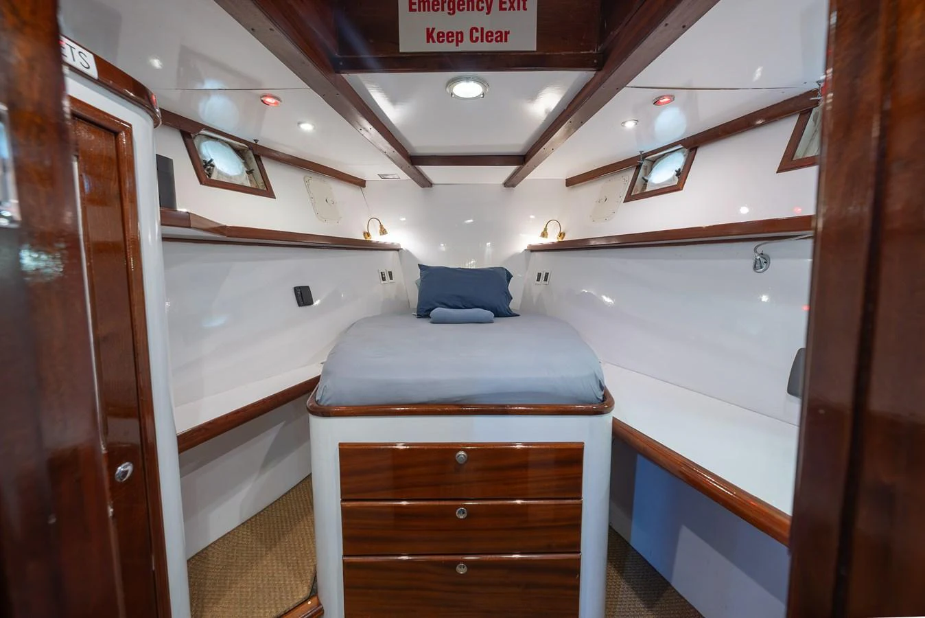 A cozy yacht cabin featuring a comfortable bed and ample storage space. aboard INNISFAIL Yacht for Sale