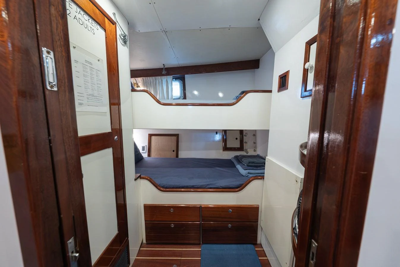 A cozy cabin with bunk beds and wooden accents offers a comfortable retreat. aboard INNISFAIL Yacht for Sale