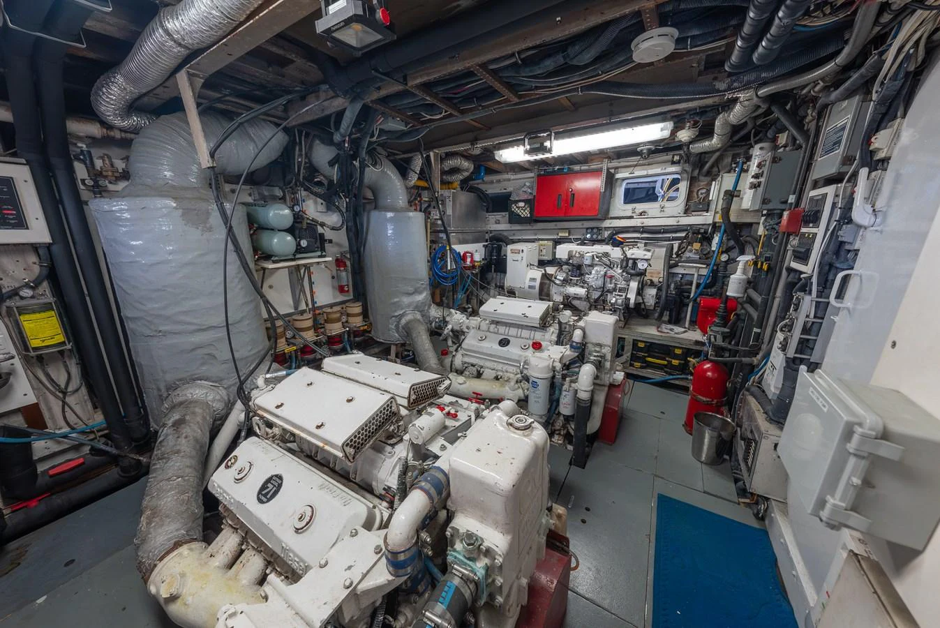 The image showcases the yacht's well-equipped engine room with multiple engines and technical equipment. aboard INNISFAIL Yacht for Sale