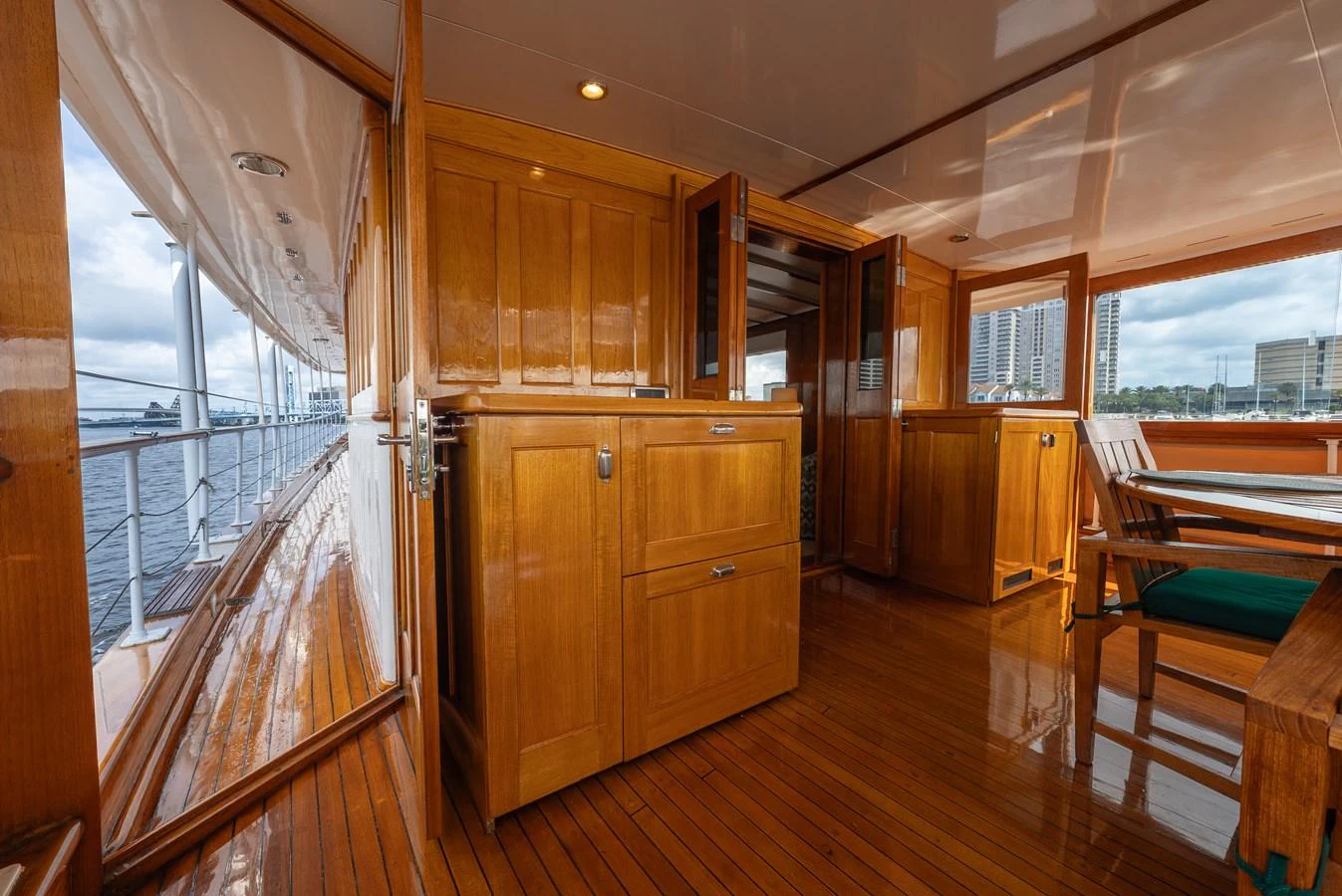The aft deck features polished wooden cabinetry and ample seating with a view of the water. aboard INNISFAIL Yacht for Sale