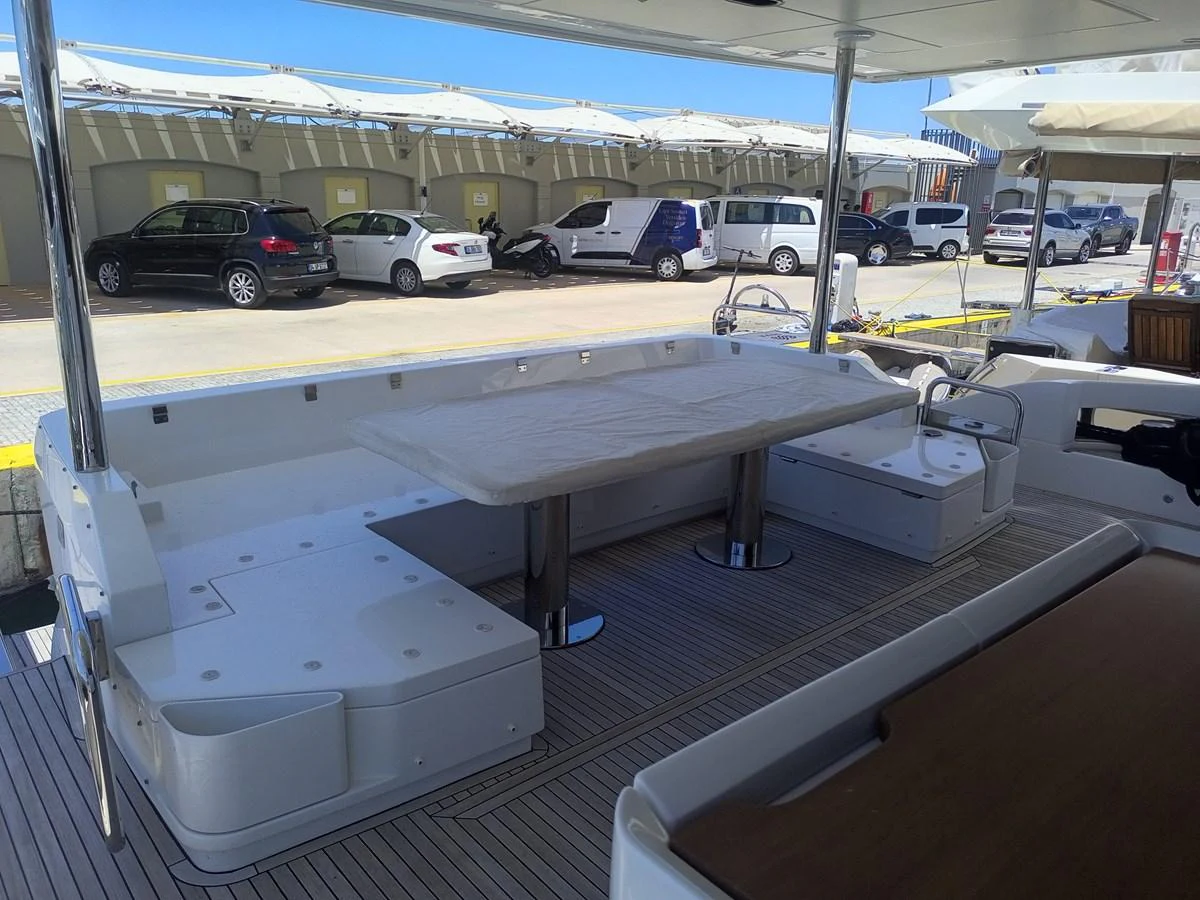 The aft deck features a spacious seating area with a large table, perfect for outdoor dining and relaxation. aboard LIL Yacht for Sale