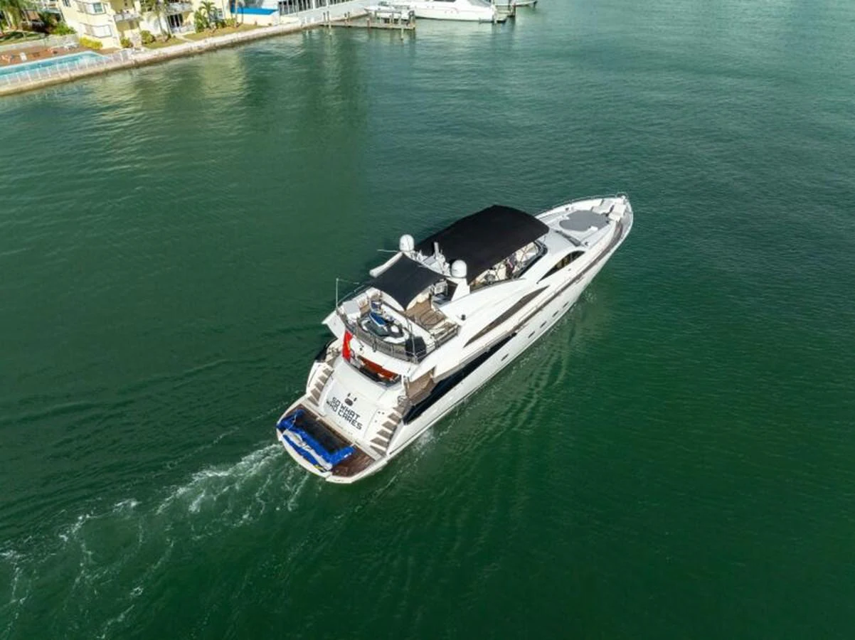 A sleek and modern yacht cruises through calm waters, showcasing its elegant design and spacious deck areas. aboard SO WHAT WHO CARES Yacht for Sale