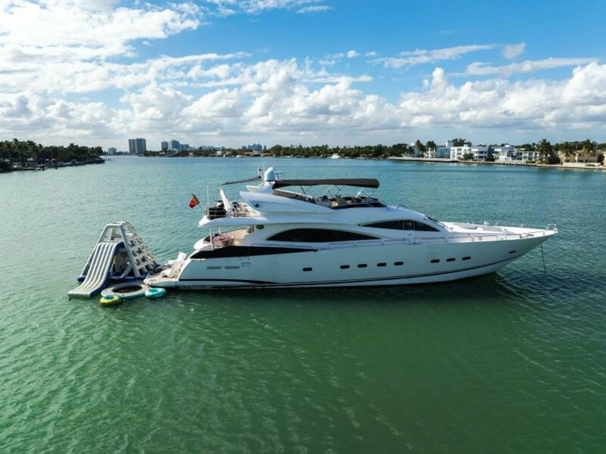 A sleek and modern yacht cruising on calm waters under a partly cloudy sky. aboard SO WHAT WHO CARES Yacht for Sale