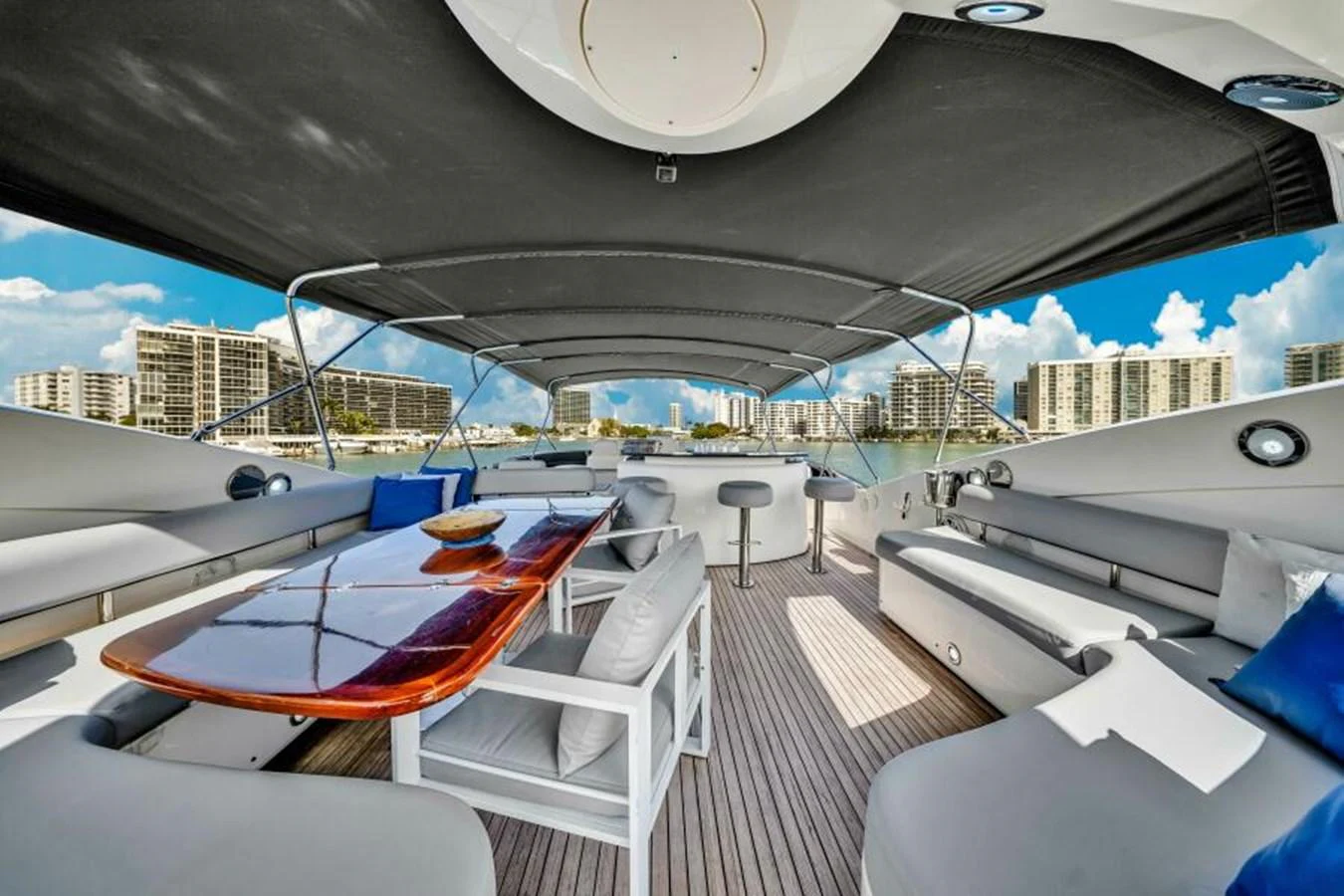 The flybridge offers a spacious and luxurious outdoor seating area with a dining table and panoramic views. aboard SO WHAT WHO CARES Yacht for Sale