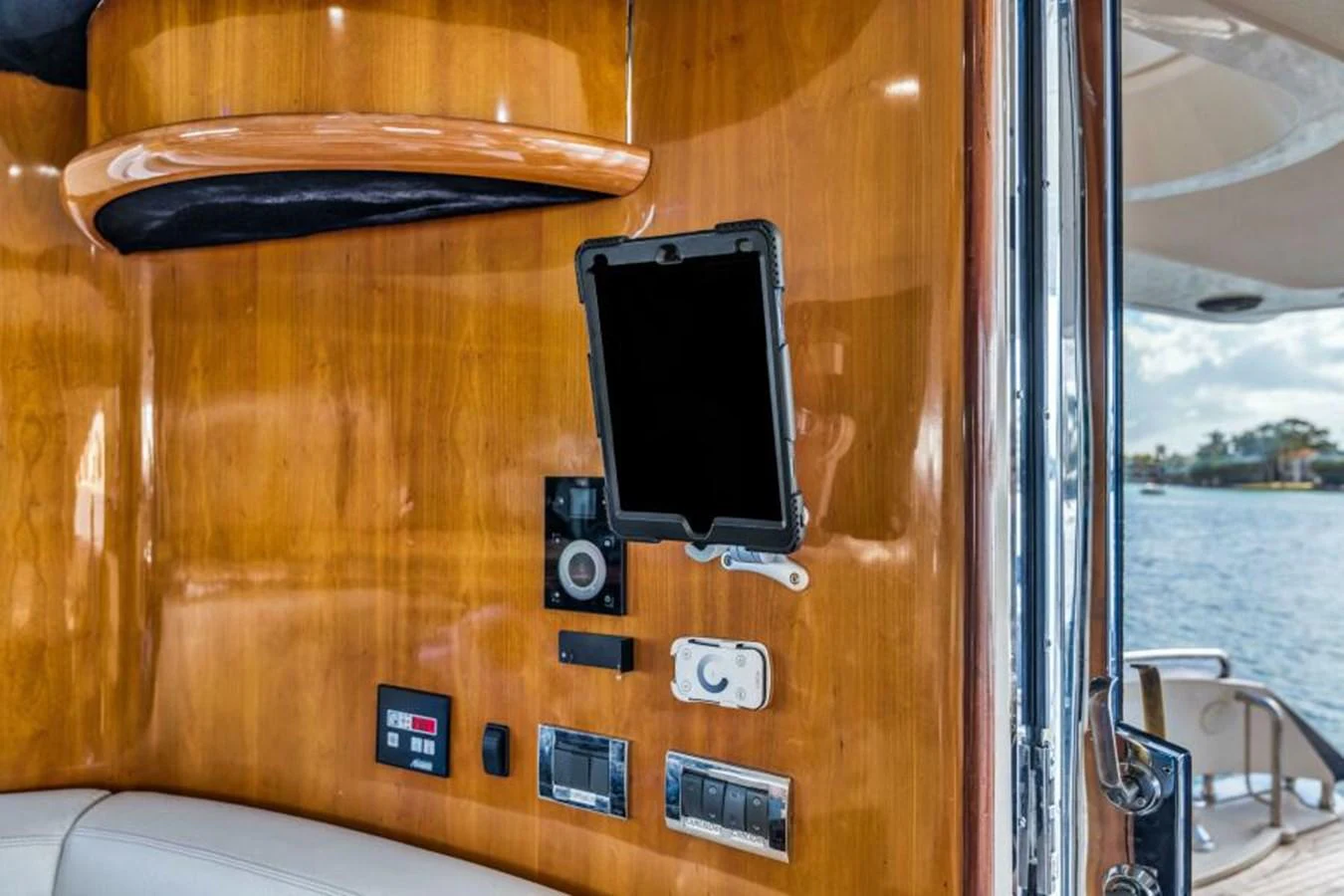 A close-up view of the yacht's control panel and electronic devices against a polished wooden wall. aboard SO WHAT WHO CARES Yacht for Sale