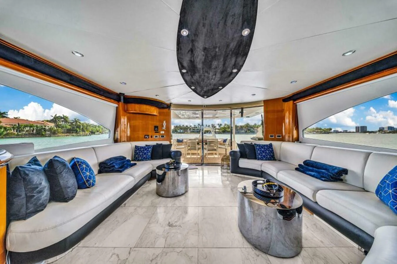 The salon features luxurious seating with elegant decor and expansive windows offering stunning views. aboard SO WHAT WHO CARES Yacht for Sale
