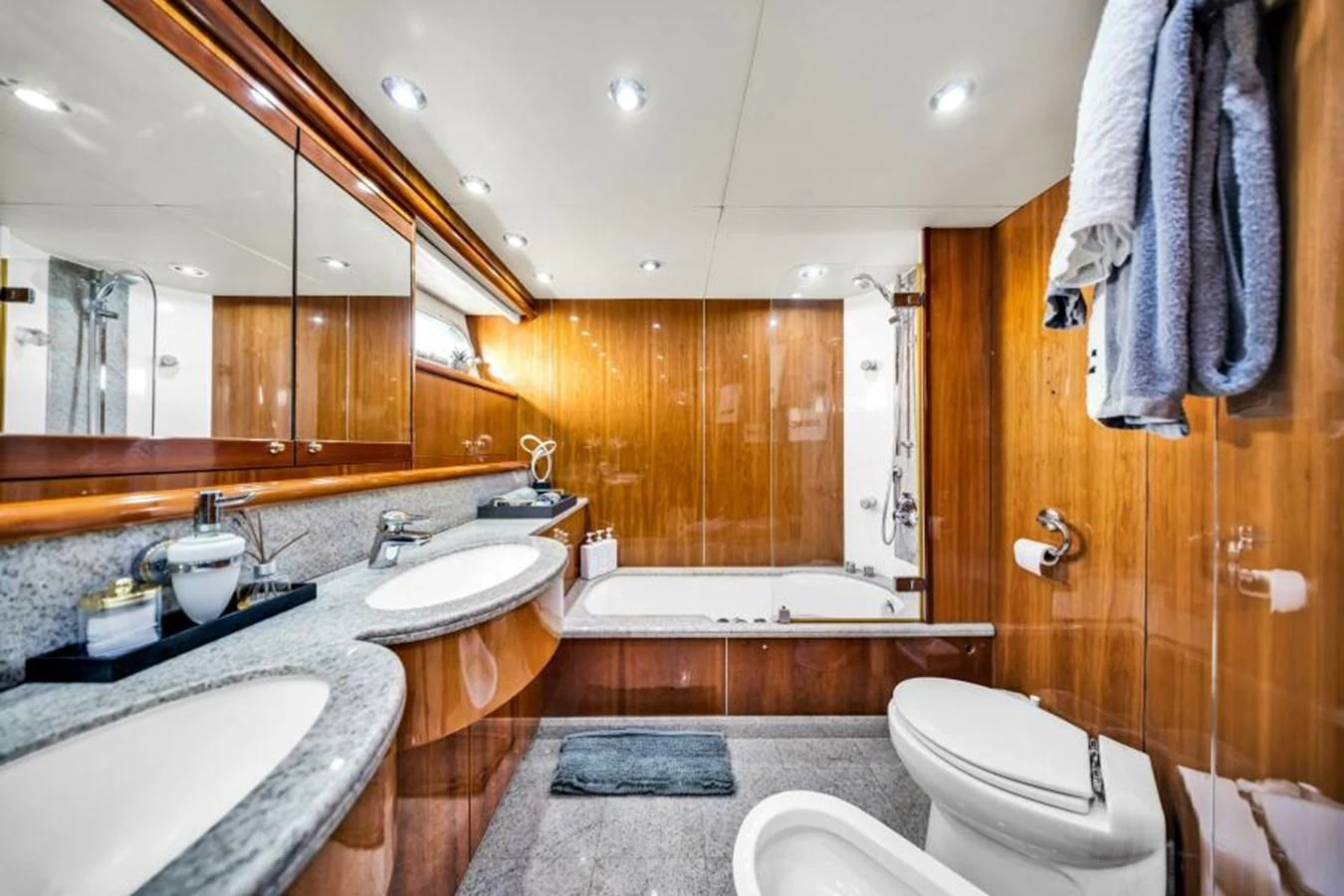 The yacht's bathroom features elegant wood paneling and modern fixtures. aboard SO WHAT WHO CARES Yacht for Sale