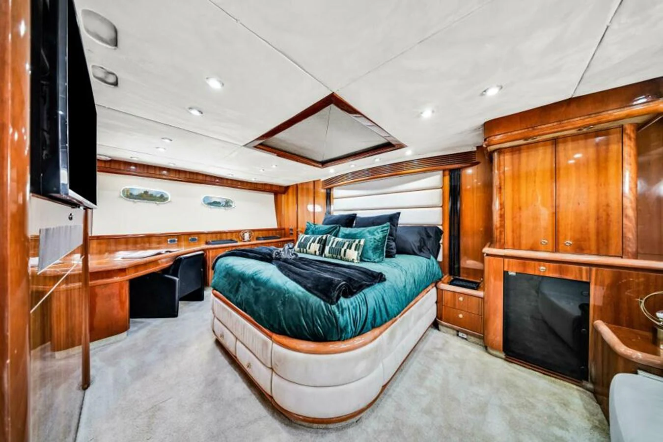 The master stateroom features a luxurious bed with elegant wood paneling and ample storage space. aboard SO WHAT WHO CARES Yacht for Sale