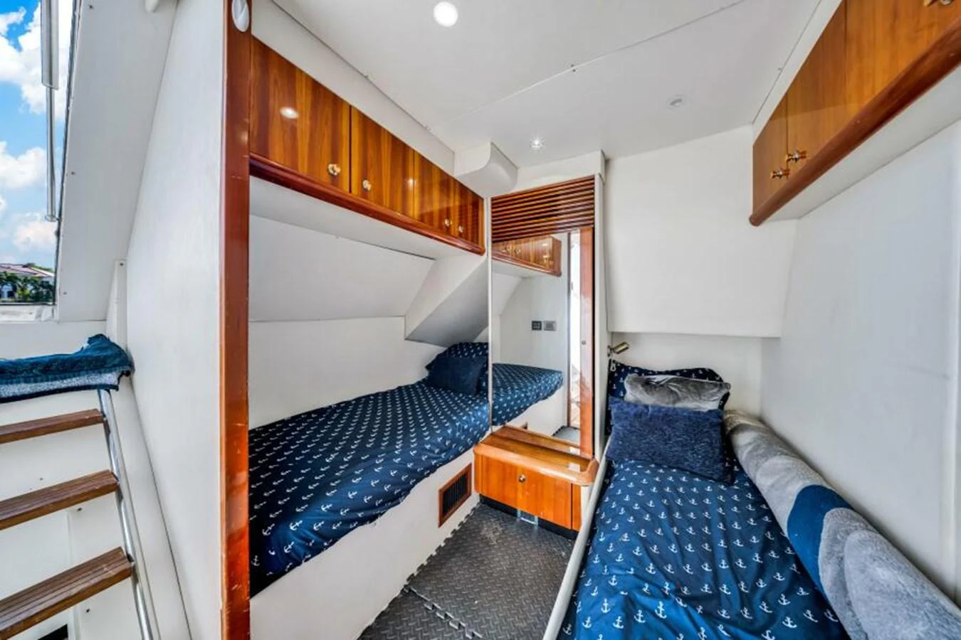 A cozy guest cabin featuring twin beds with nautical-themed bedding. aboard SO WHAT WHO CARES Yacht for Sale