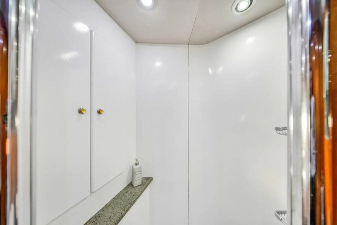 A clean and modern yacht bathroom with white walls and cabinetry. aboard SO WHAT WHO CARES Yacht for Sale