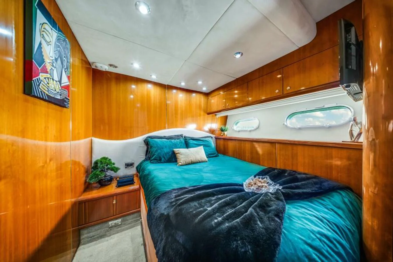 A cozy stateroom with a plush bed and elegant wood paneling. aboard SO WHAT WHO CARES Yacht for Sale