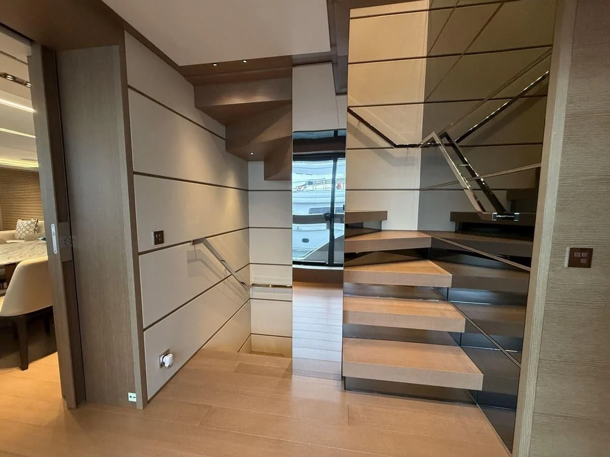A modern yacht interior featuring a sleek wooden staircase with mirrored walls. aboard PHOENICIAN Yacht for Sale