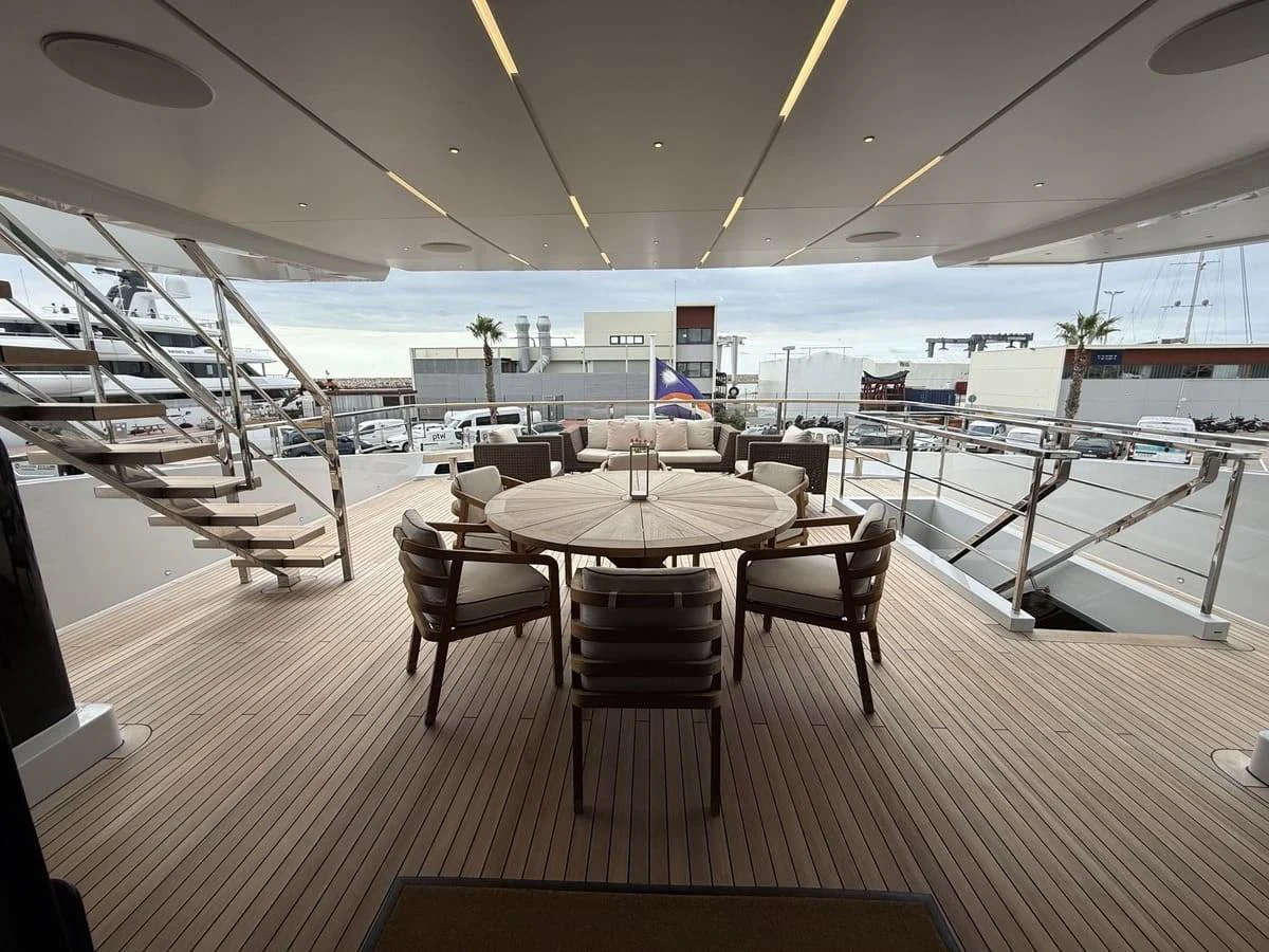 The aft deck features a stylish dining area with a round table and comfortable chairs, perfect for al fresco dining. aboard PHOENICIAN Yacht for Sale