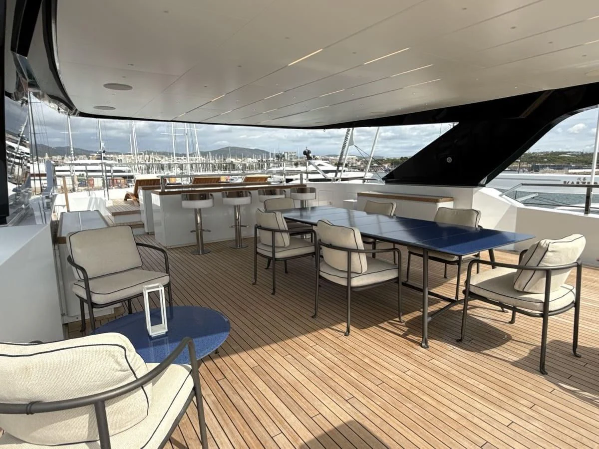 The aft deck features a spacious seating area with comfortable chairs and a large table, perfect for outdoor relaxation and dining. aboard PHOENICIAN Yacht for Sale