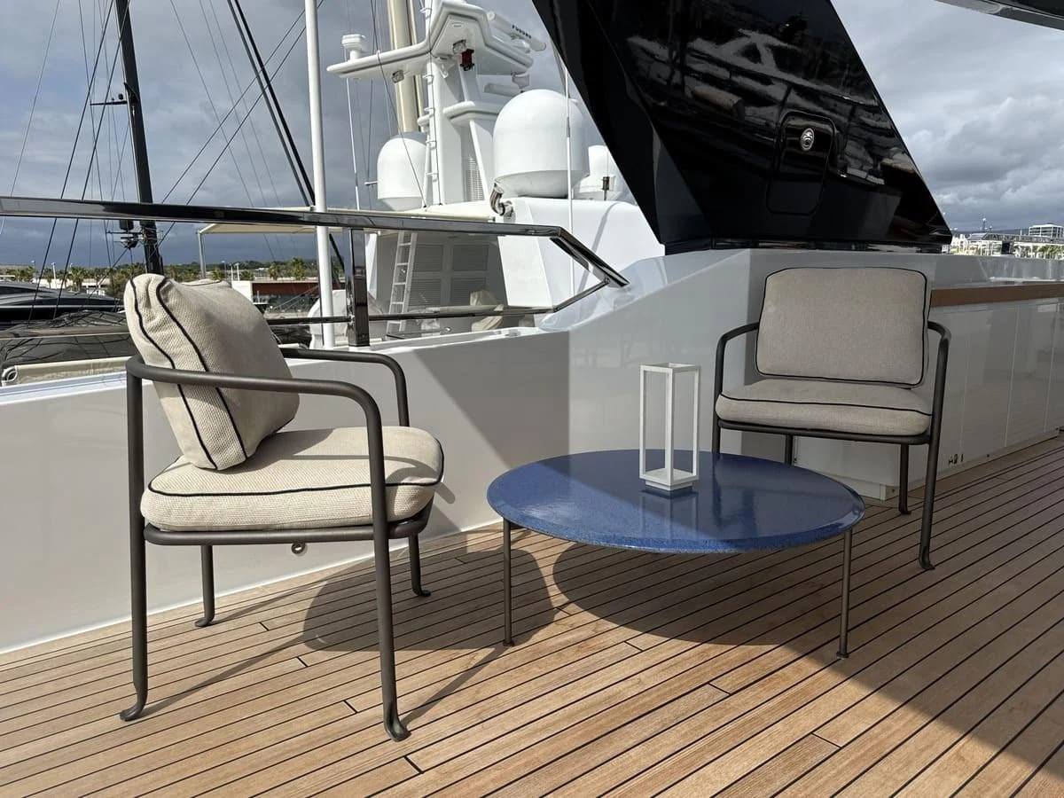 The aft deck features a cozy seating area with modern chairs and a sleek table, perfect for relaxation. aboard PHOENICIAN Yacht for Sale
