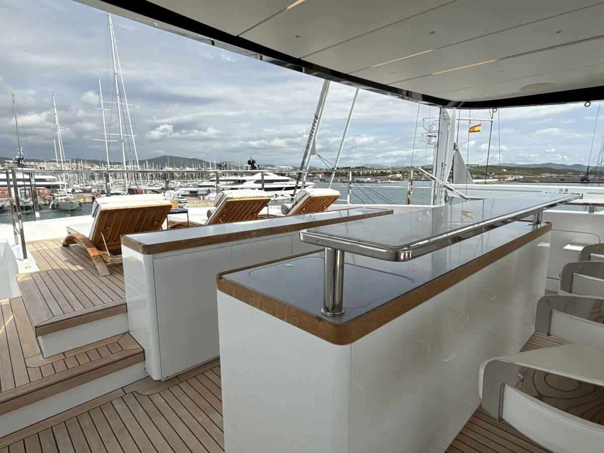 The flybridge offers a luxurious space with a bar and sun loungers, perfect for relaxation and entertainment. aboard PHOENICIAN Yacht for Sale