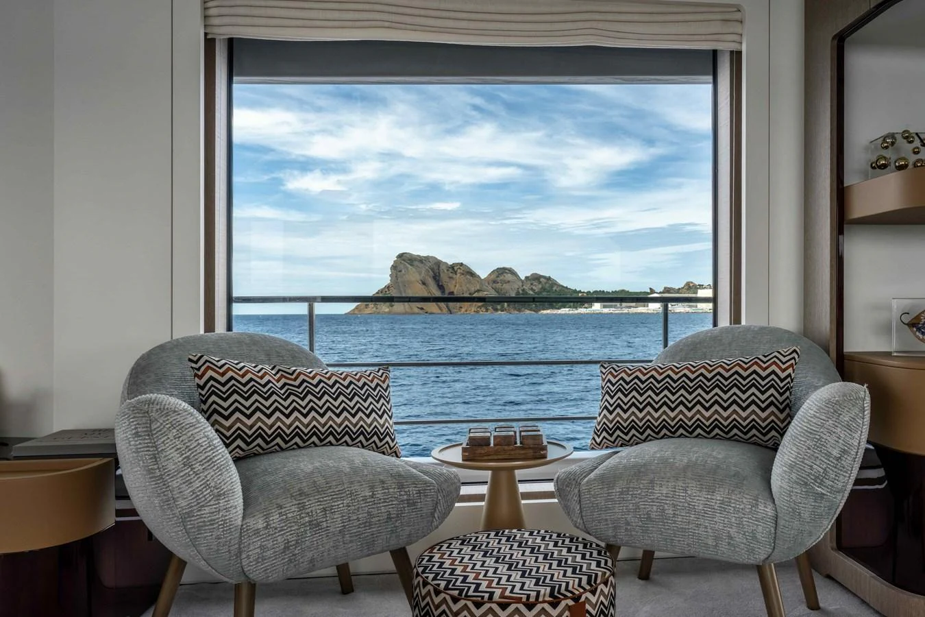 The salon offers a cozy seating area with a stunning ocean view through a large window. aboard ST JUDE Yacht for Sale