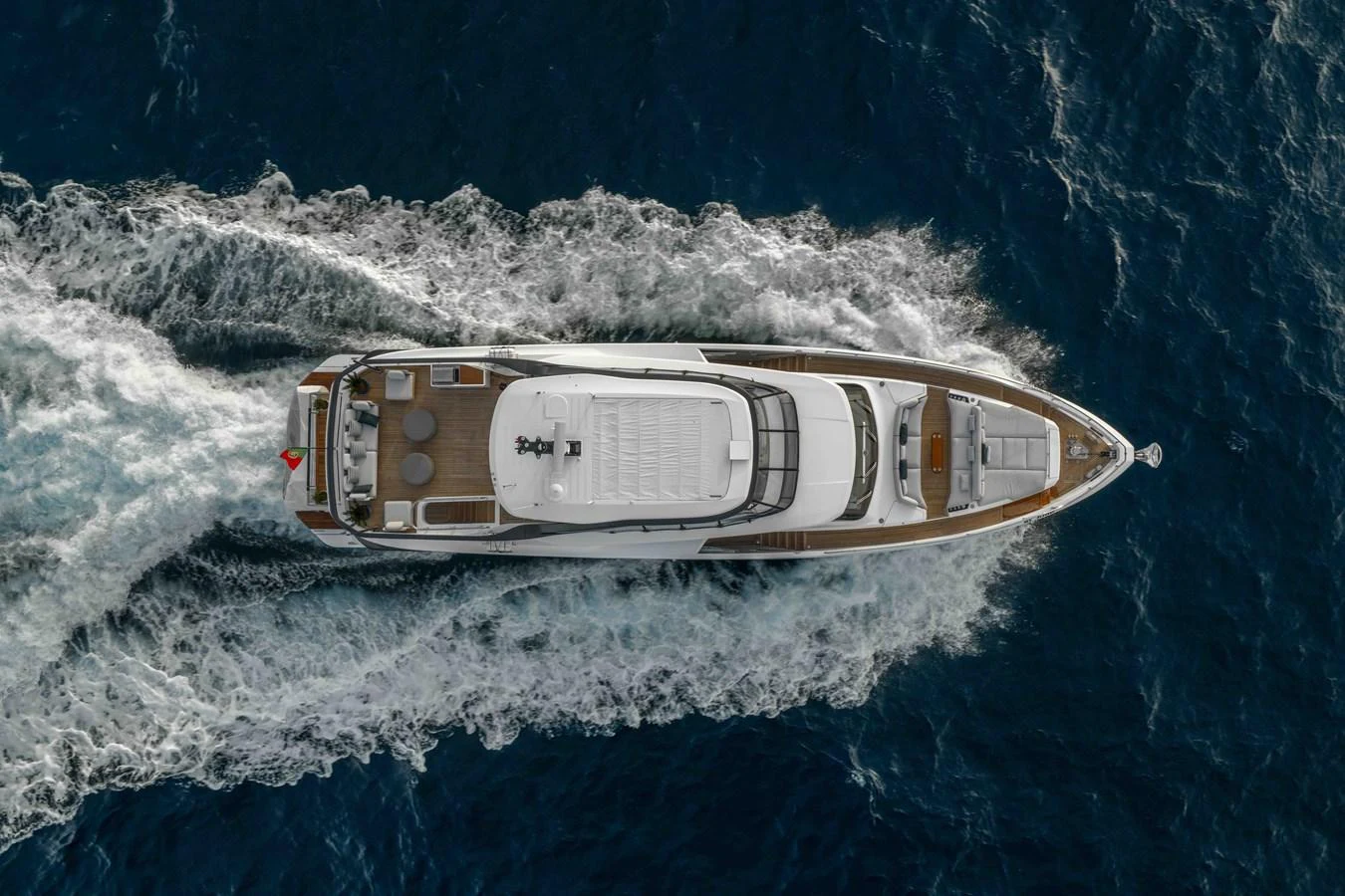 An aerial view of a sleek yacht cruising through the open sea, showcasing its elegant design and powerful performance. aboard ST JUDE Yacht for Sale