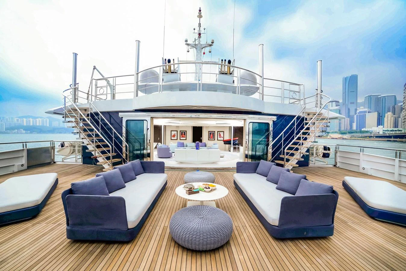 The aft deck features luxurious seating arrangements with a stunning cityscape view. aboard SALUZI Yacht for Sale