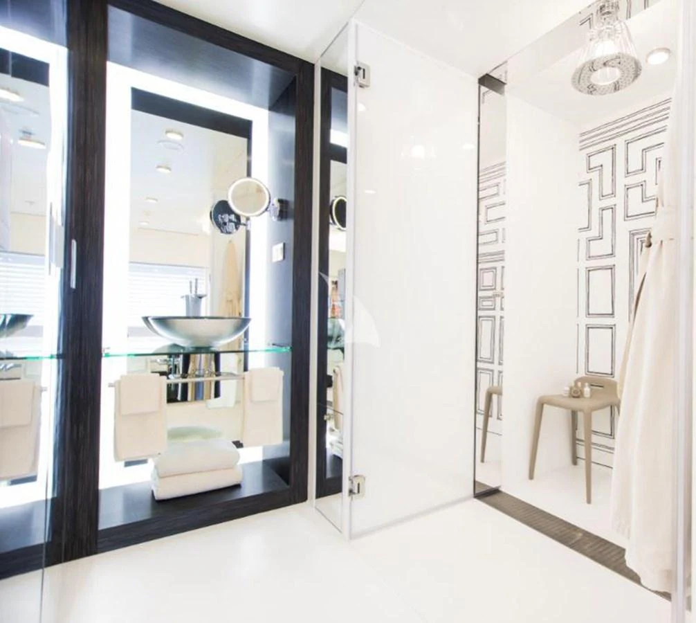 The yacht's bathroom features a modern design with a glass sink and a spacious shower area. aboard SALUZI Yacht for Sale