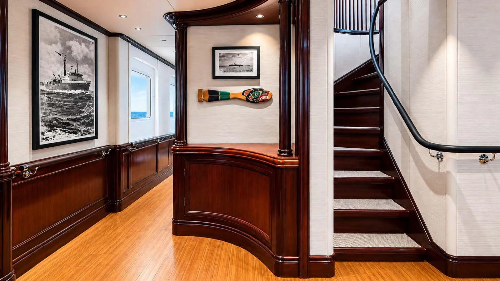 The yacht's interior showcases elegant wood paneling and a staircase leading to the upper deck. aboard JUST B Yacht for Sale