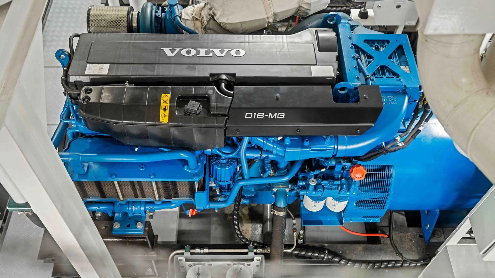 The image showcases a powerful Volvo D16-MG engine in the yacht's engine room. aboard JUST B Yacht for Sale