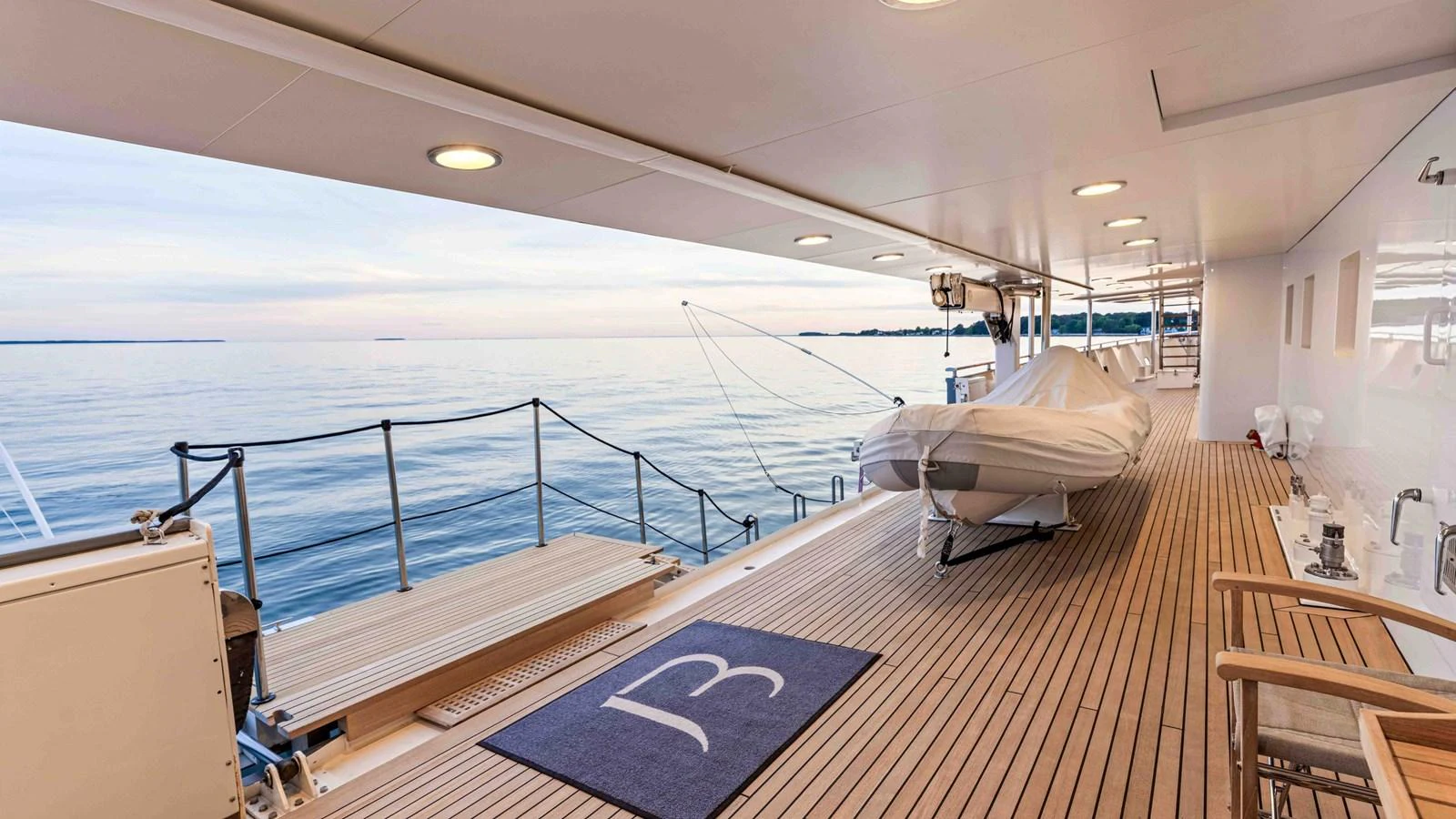 The aft deck offers a serene view of the water, complemented by comfortable seating and a tender. aboard JUST B Yacht for Sale