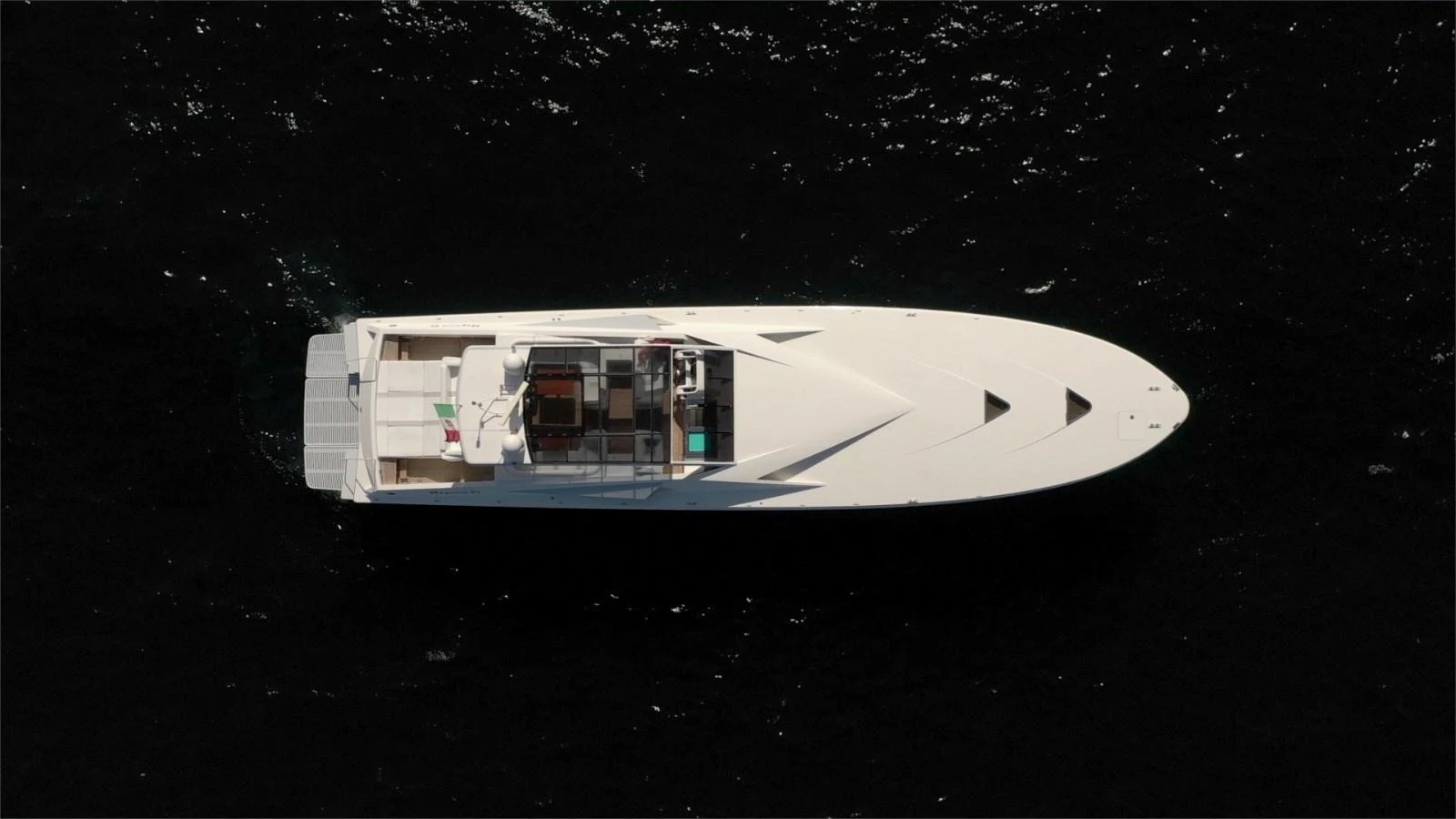 A sleek, modern yacht is captured from an aerial view, showcasing its streamlined design and spacious deck layout. aboard WHITE & SILVER Yacht for Sale