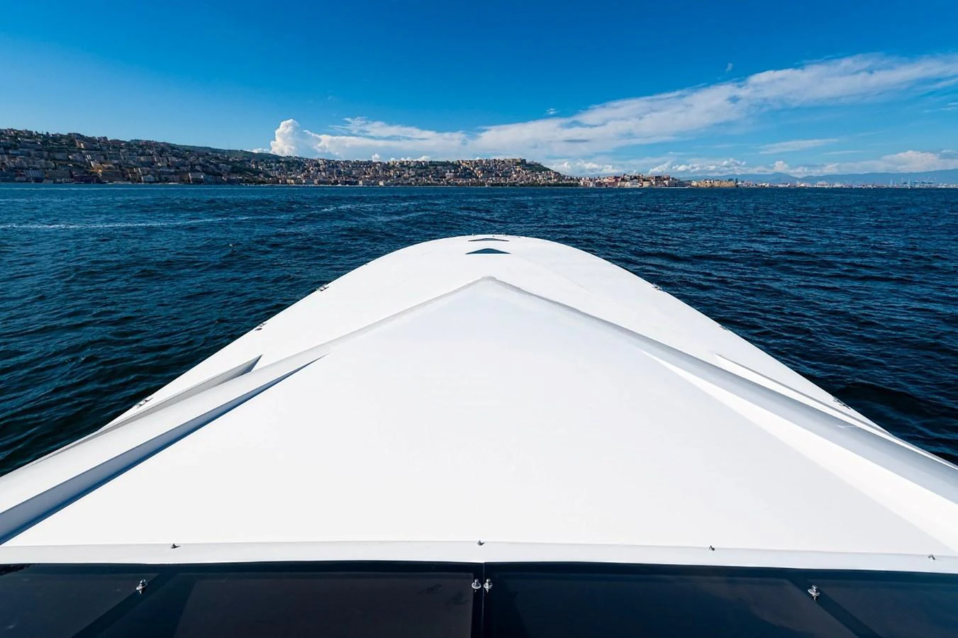 The yacht's sleek bow cuts through the water under a clear blue sky. aboard WHITE & SILVER Yacht for Sale
