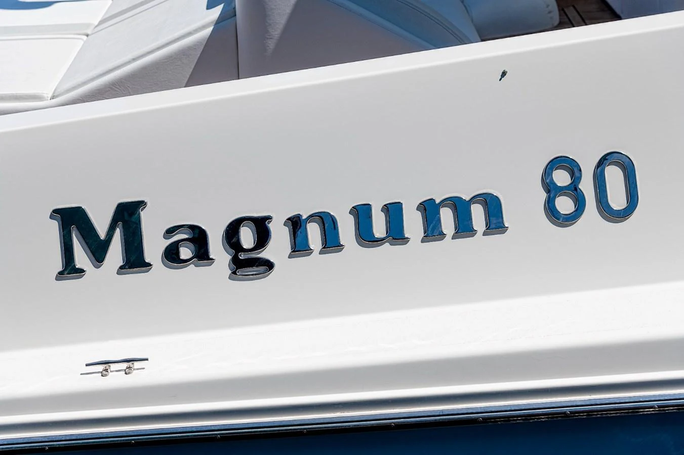 A close-up view of the yacht's name, 'Magnum 80', elegantly displayed on the hull. aboard WHITE & SILVER Yacht for Sale