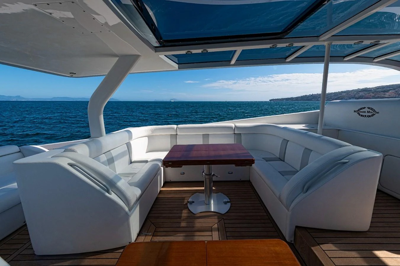 The aft deck features a spacious seating area with a central table, perfect for enjoying the ocean views. aboard WHITE & SILVER Yacht for Sale