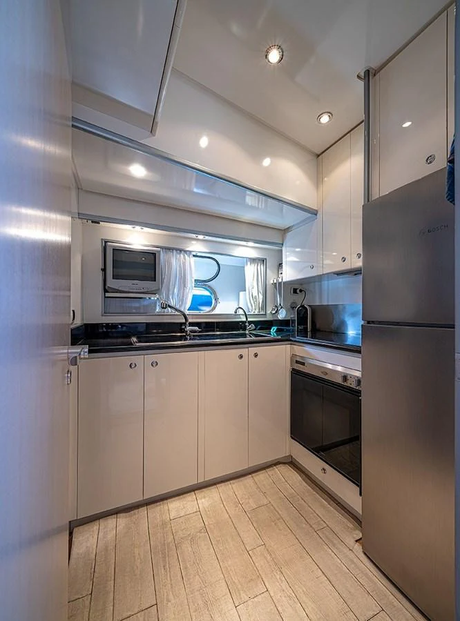 The yacht's galley is equipped with modern appliances and sleek cabinetry, offering a functional and stylish cooking space. aboard WHITE & SILVER Yacht for Sale